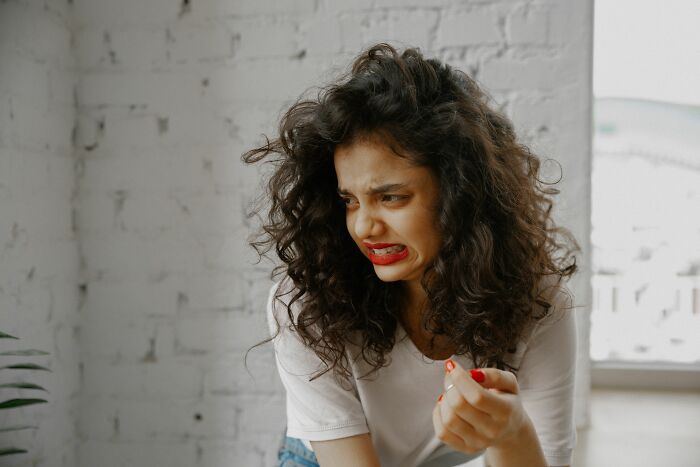 A woman making a disgusted face, rolling her eyes at men and their turn-offs.