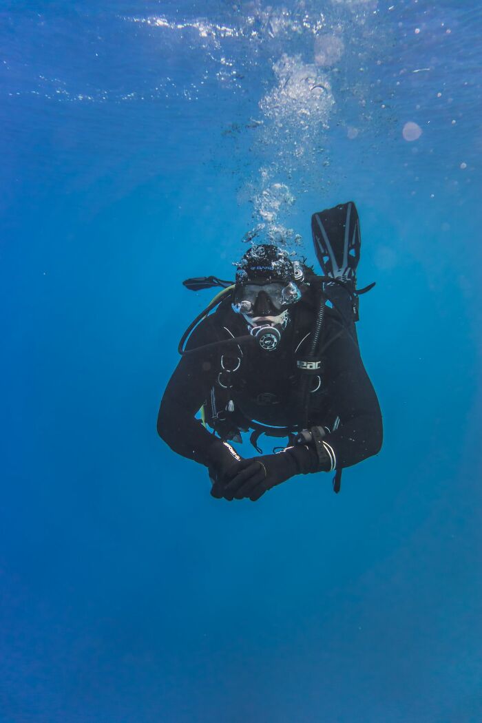 Scuba diver swimming towards the camera underwater