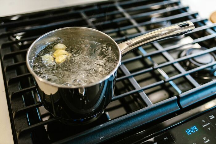A pot of boiling water with garlic cloves on a stovetop, a mundane scene potentially tied to an unserious ER visit.