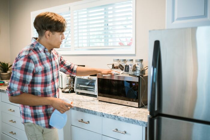 Man using microwave oven in kitchen representing scientific questions