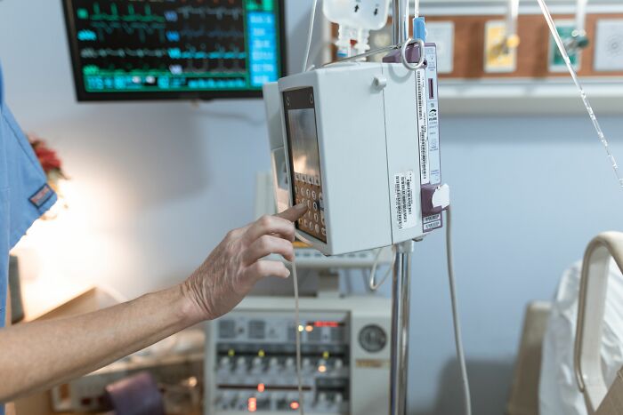 Person adjusting medical equipment in hospital showing science technology