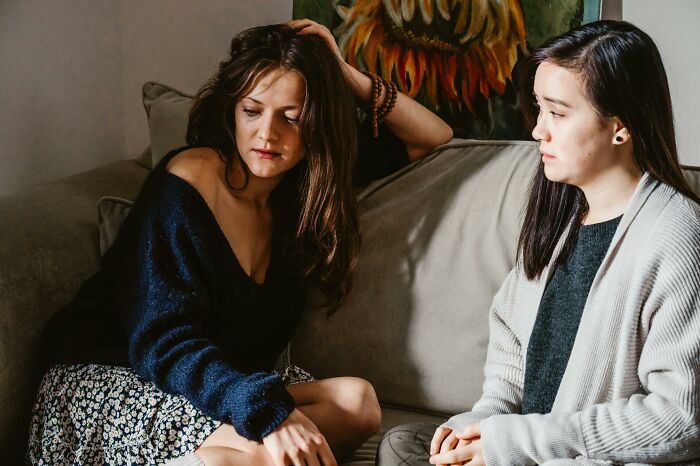 Two women having a serious conversation on a couch