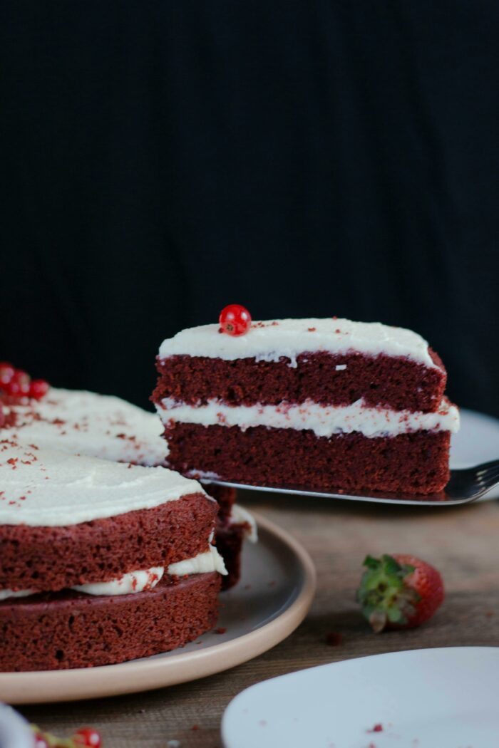 Slice of red velvet gender reveal cake with white frosting Slice of red velvet gender reveal cake with white frosting