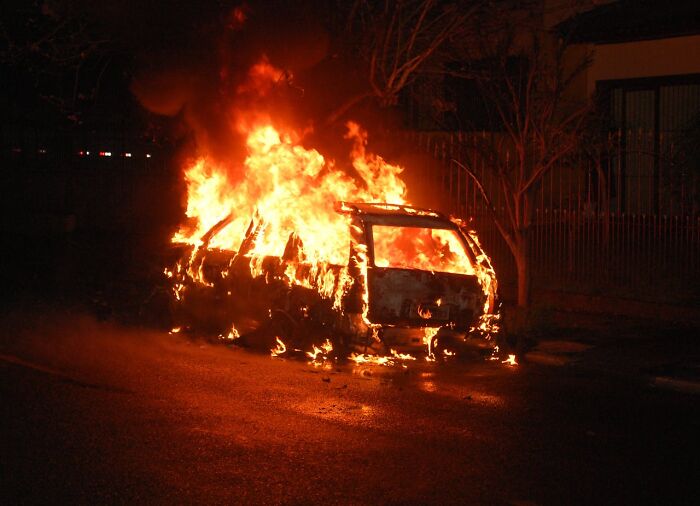 Car engulfed in large flames burning intensely at night