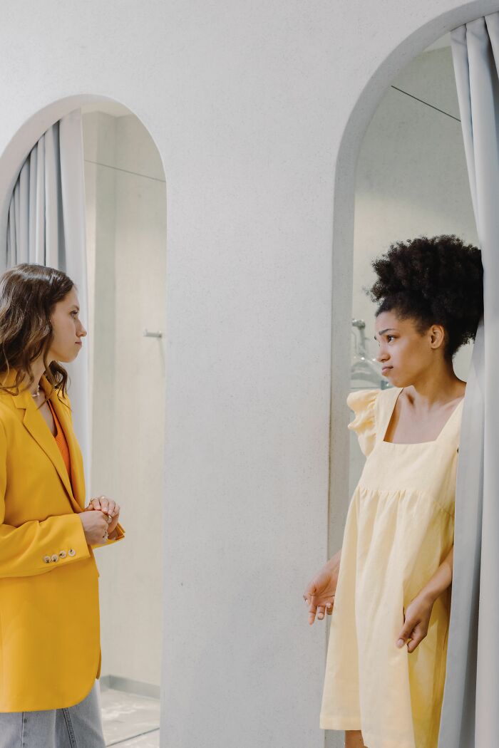 Two women in a dressing room misread social cues, resulting in an awkward stare.