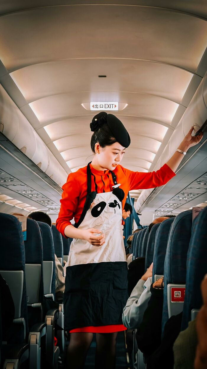 Flight attendant walking in airplane aisle during flight safety service