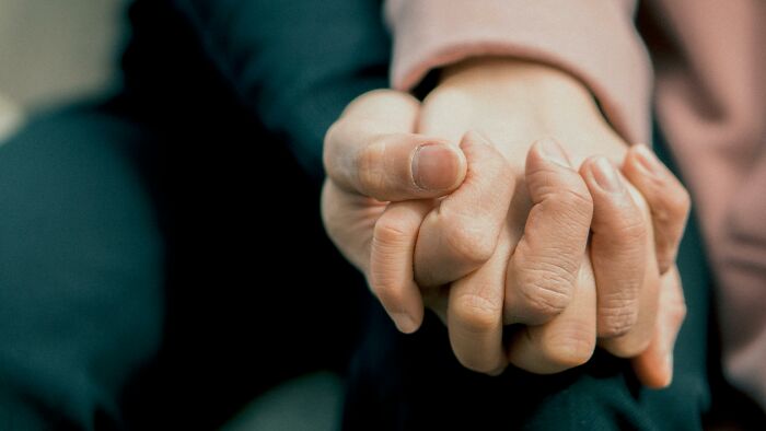 Two hands holding each other in a gesture of pure generosity