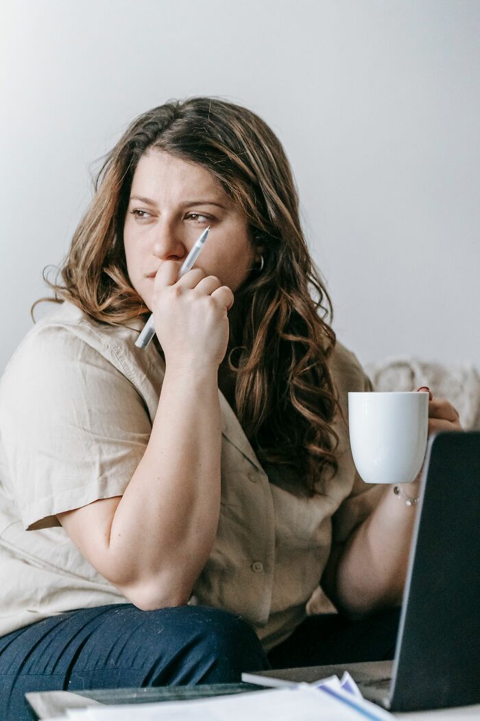 Worried woman thinking while holding coffee with cheating doubts
