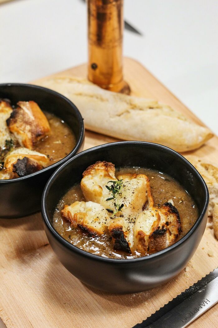 French onion soup with toasted bread and herbs on wooden board food facts