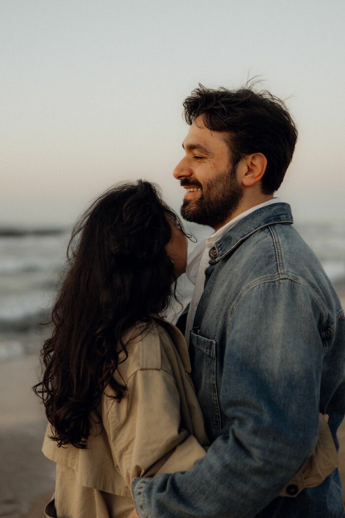 A man and a woman embracing on a beach, highlighting the intricate NSFW facts about human bodies.