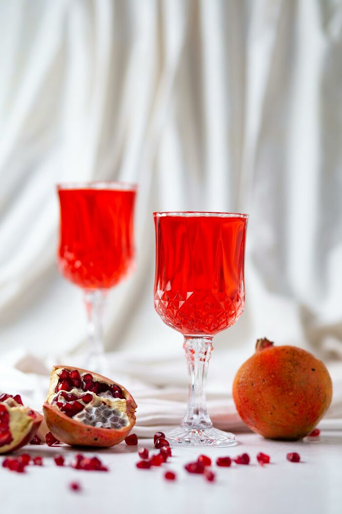 Glasses of pomegranate juice with fresh pomegranate seeds, fresh food facts