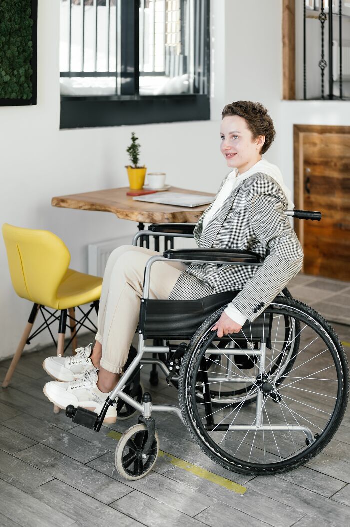 A person in a wheelchair misreads social cues in a cafe, creating an awkward moment.