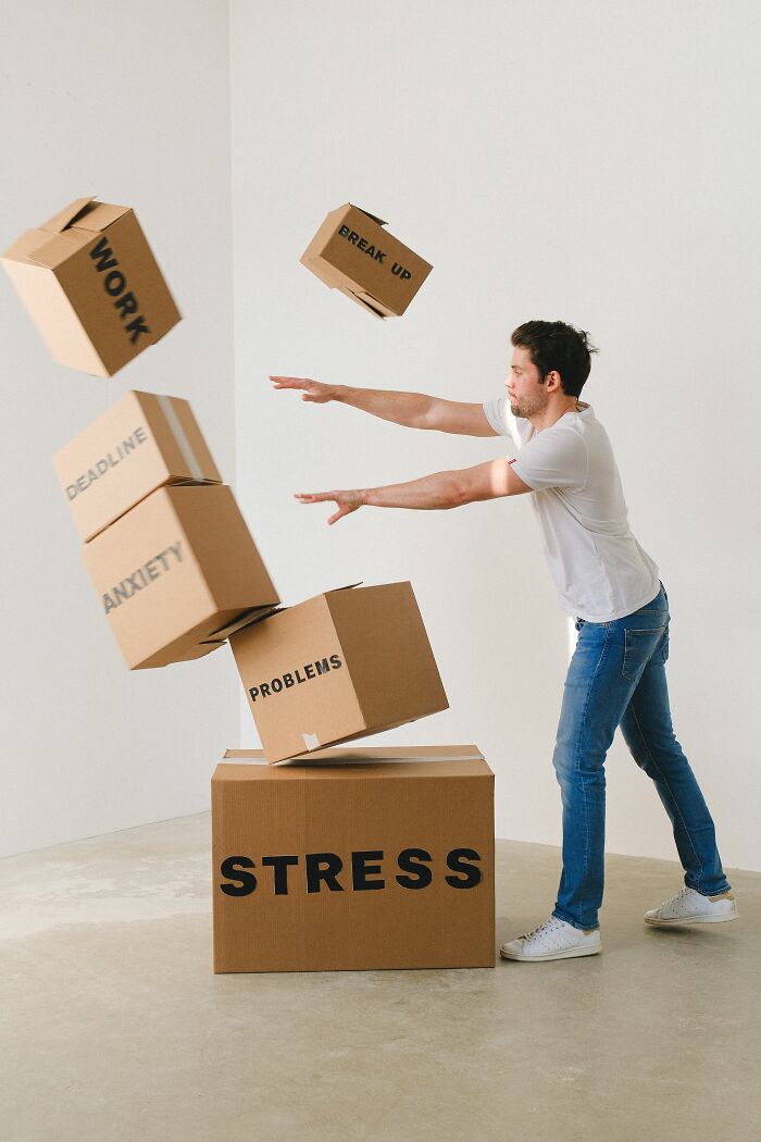 Man juggling boxes labeled stress and anxiety showing anxiety pressure