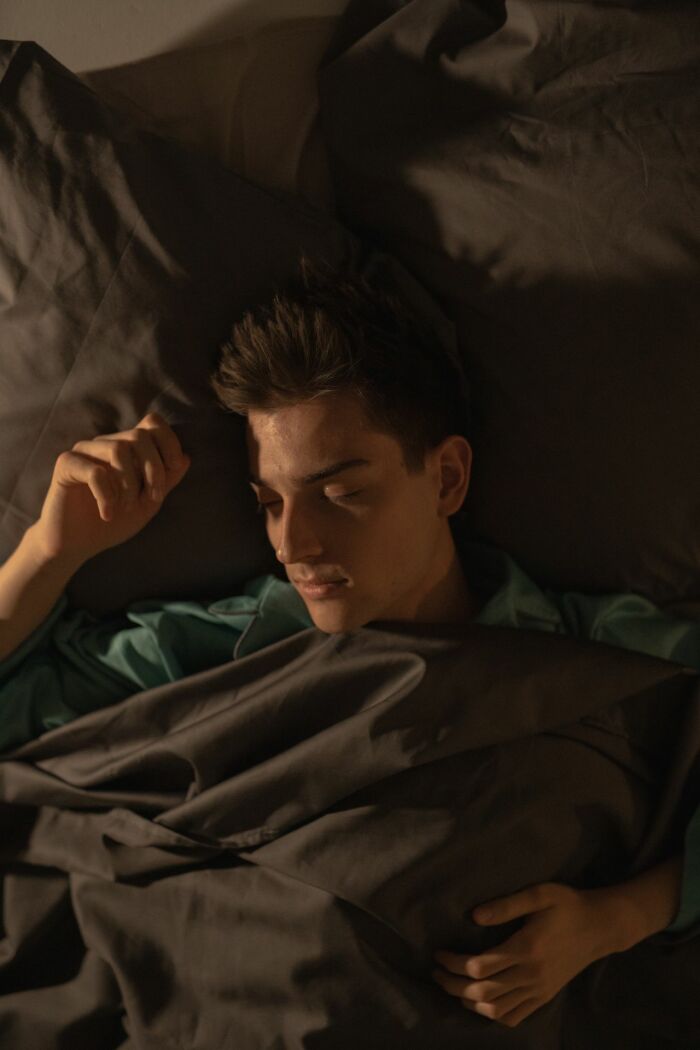 A man sleeping soundly in a bed, illustrating the phrase Felt The Bed Compress and experiences people can't explain.