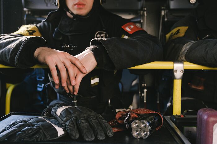 Firefighter resting hands on table wearing gloves and uniform gear