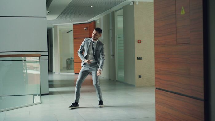 A man in a suit doing a silly dance in an office hallway, illustrating the wild nature of courtroom stories.