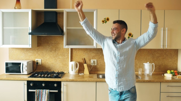 A happy man celebrating in a kitchen, realizing his fiancée is the problem and he needs his money back. A happy man celebrating in a kitchen, realizing his fiancée is the problem and he needs his money back.