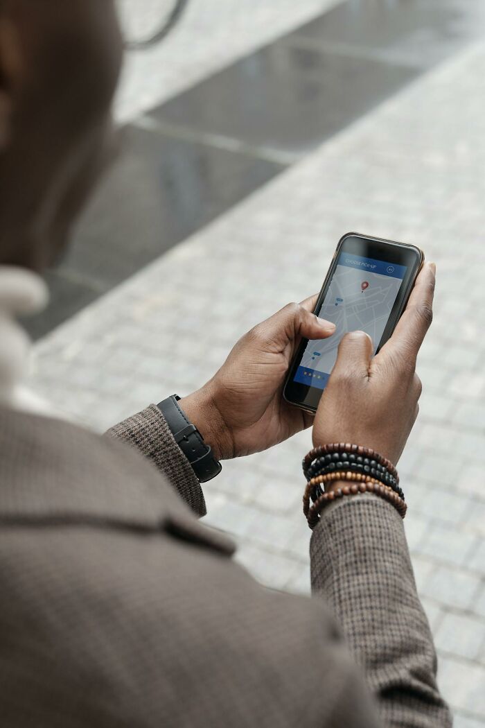 Person using smartphone showing location app outdoors