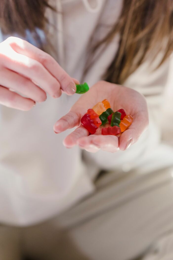 A hand holding a pile of colorful gummy bears, representing one of the most unserious ER visits.