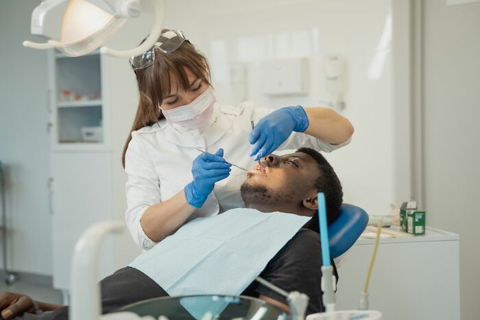 Dentist examining a patient, illustrating types of pain people experience.