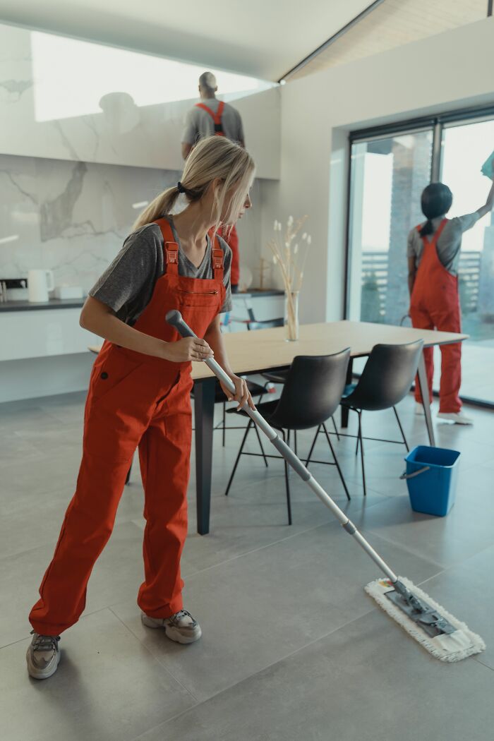 Cleaning crew mopping a floor, a surprising fact about professional cleaning services.