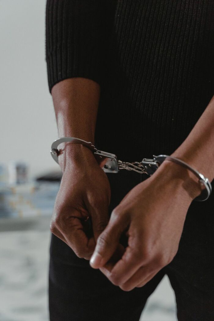 Close-up of a person's hands in handcuffs, representing a real courtroom story.