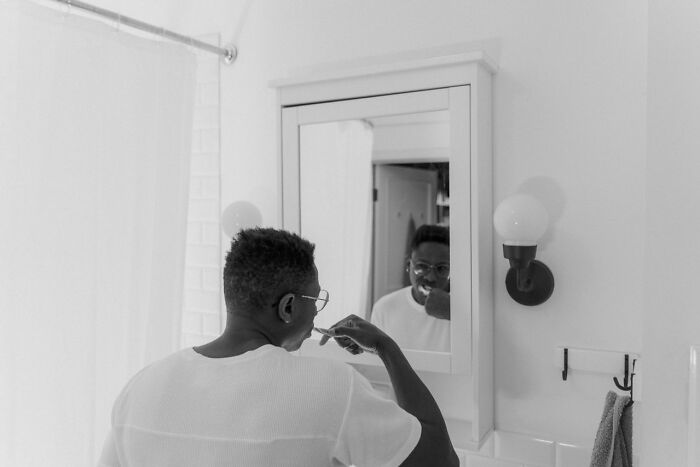 A man brushing his teeth in a mirror, reflecting a creepy and unbelievable experience.