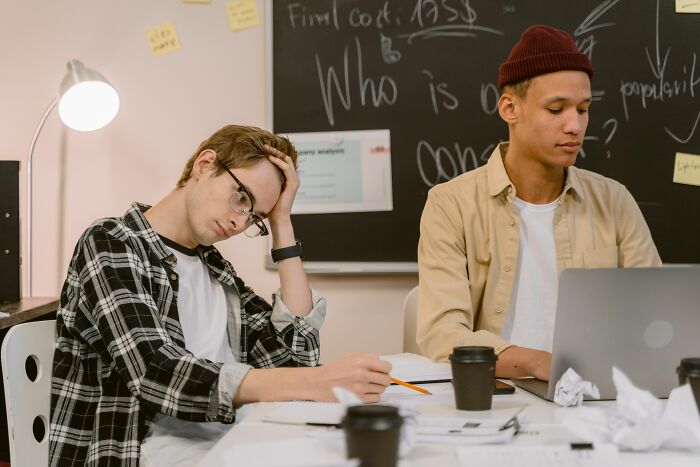 Two young men studying with one stressed, illustrating common anxiety thought patterns in psychology
