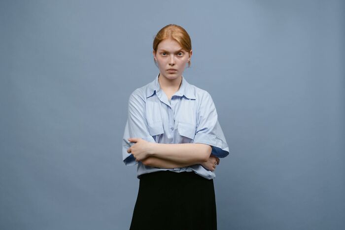 Angry woman with crossed arms showing entitled parent attitude
