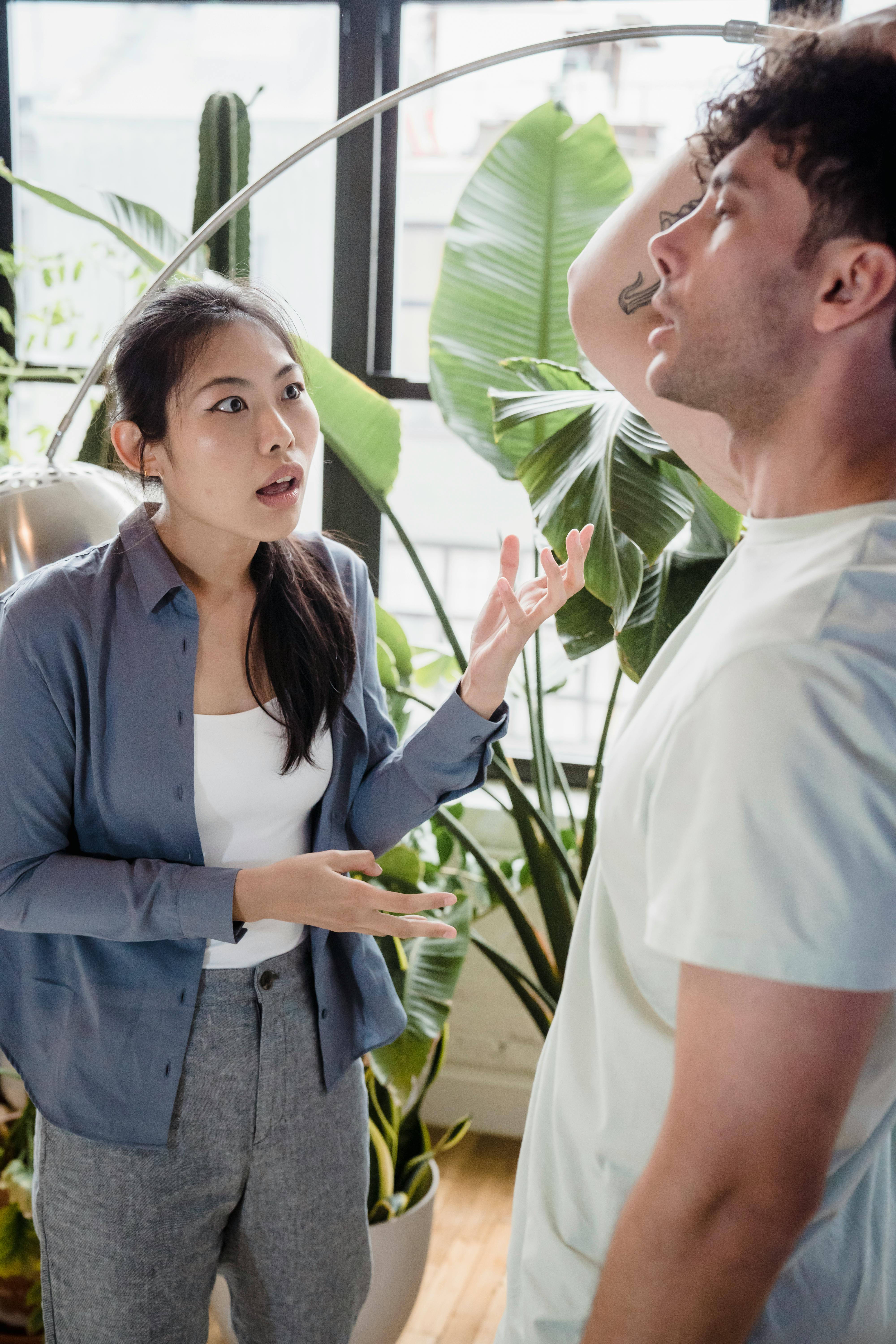 Woman angrily confronting man indoors over wedding issues