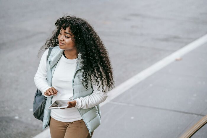Woman using digital tablet walking outdoors with generosity