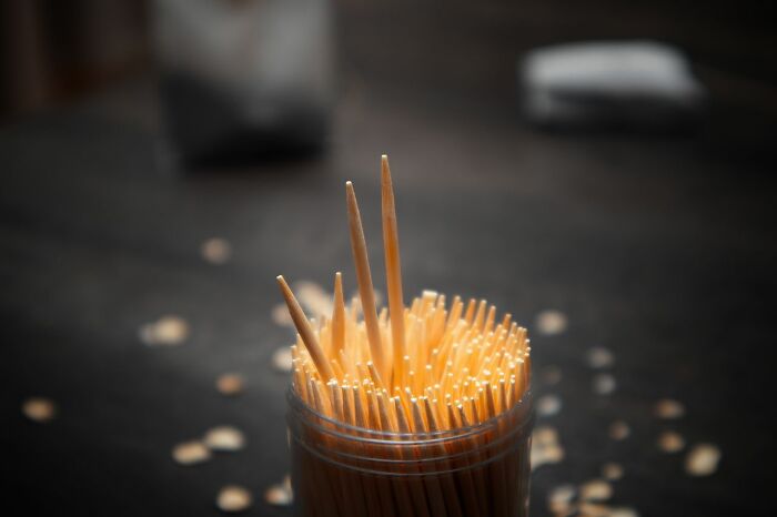 A container filled with wooden toothpicks, symbolizing a minor object or issue, relating to unserious ER visits.