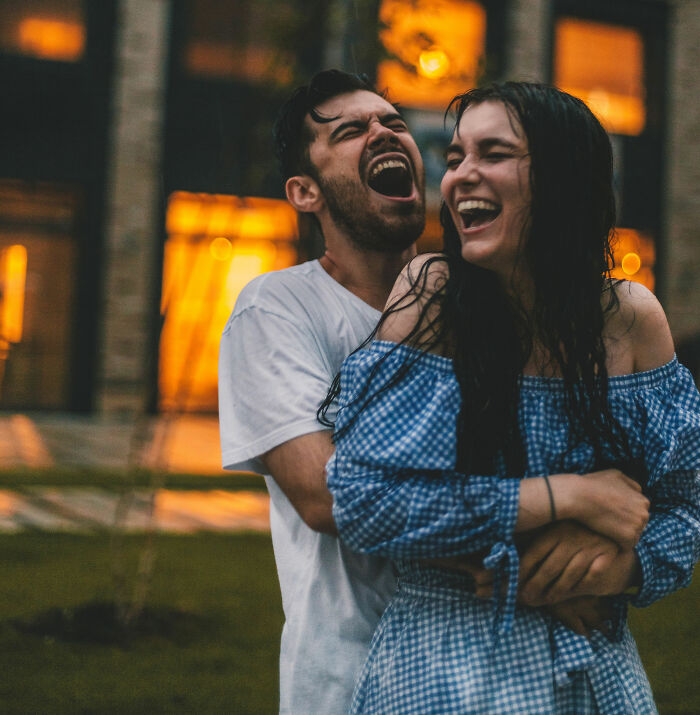 A joyful couple embraces and laughs outdoors, illustrating moments women decide to marry their partner.