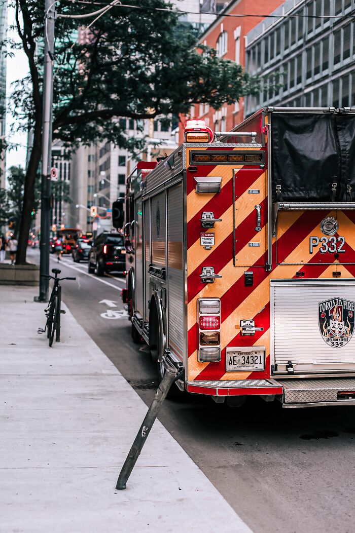 A red and yellow fire truck parked on a city street, reflecting potential misunderstandings between locals and foreigners.