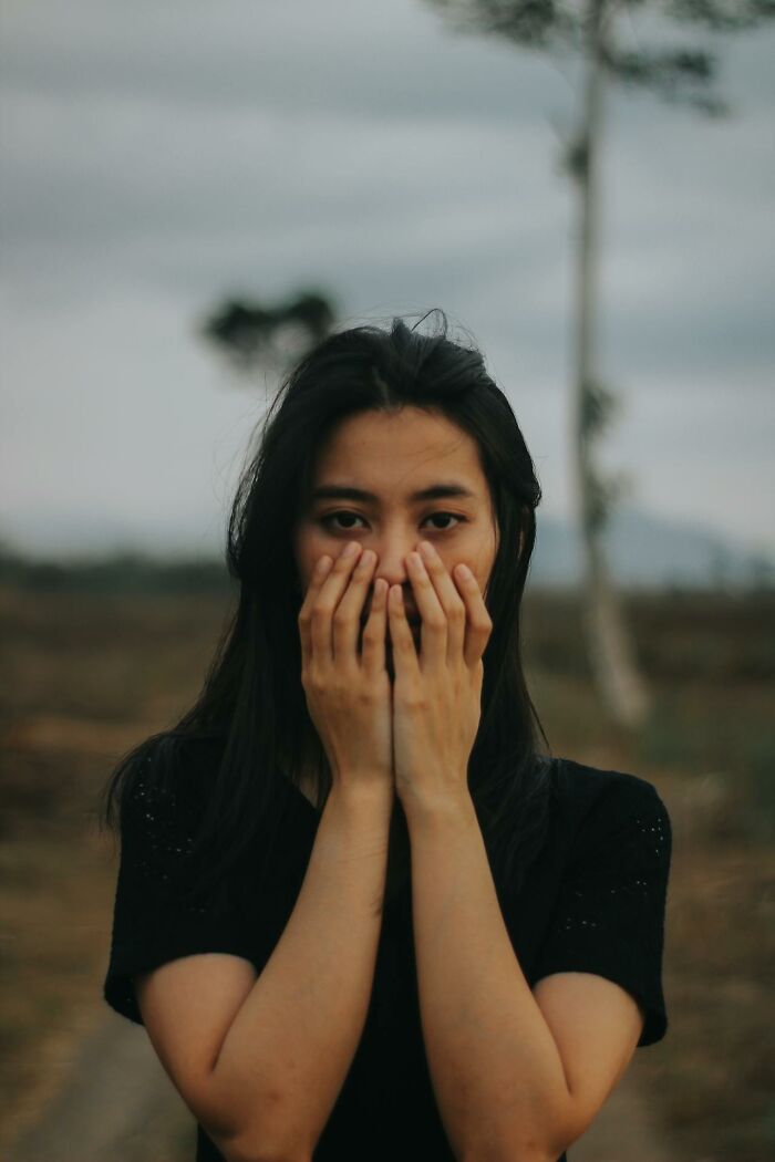 Woman covering face with hands showing anxious expression