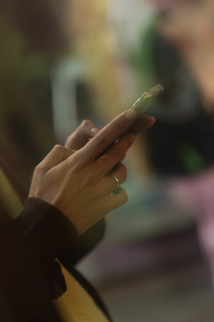 Close-up of hands holding and using a smartphone. Uncovering NSFW facts about human bodies.
