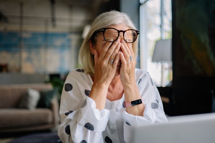 Stressed older woman rubbing eyes indoors representing MIL obsession Stressed older woman rubbing eyes indoors representing MIL obsession