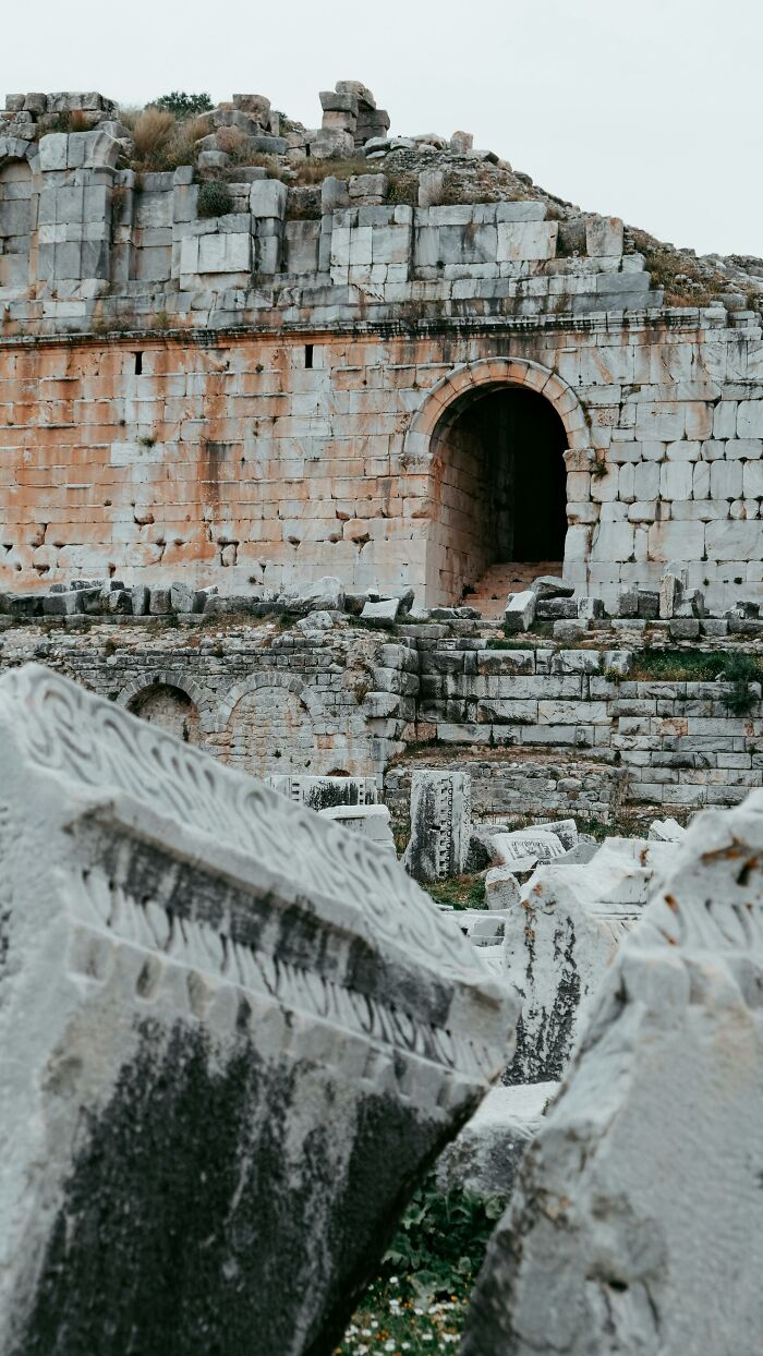 Ancient scientific ruins with stone arch and detailed carvings in outdoor setting