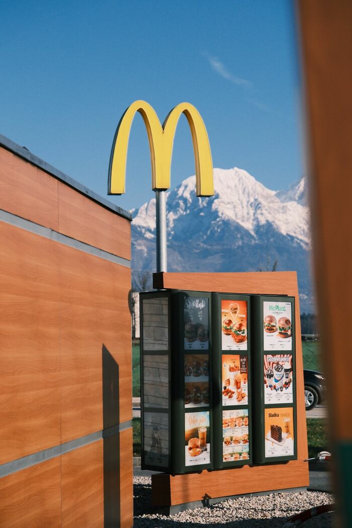 A McDonald's drive-thru sign with a snow-capped mountain backdrop, a scene for experiences people can't explain.