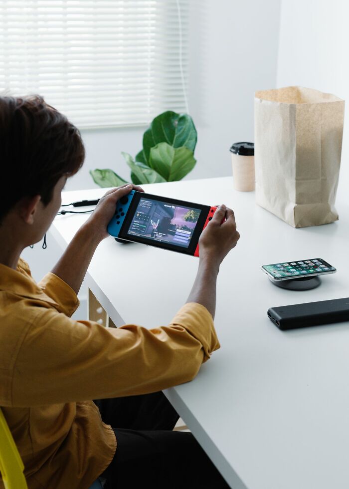 Young person playing video game ignoring responsibilities