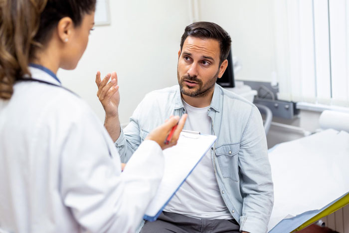 Man discussing eye care concerns with a licensed optician in clinical setting