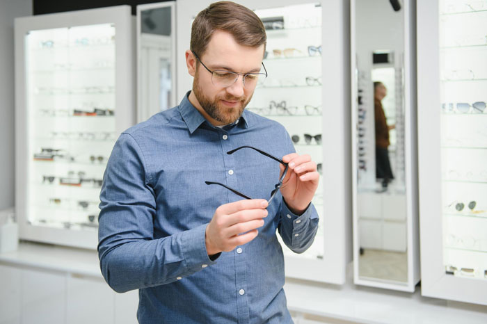 Customer examining glasses frames in an optician store