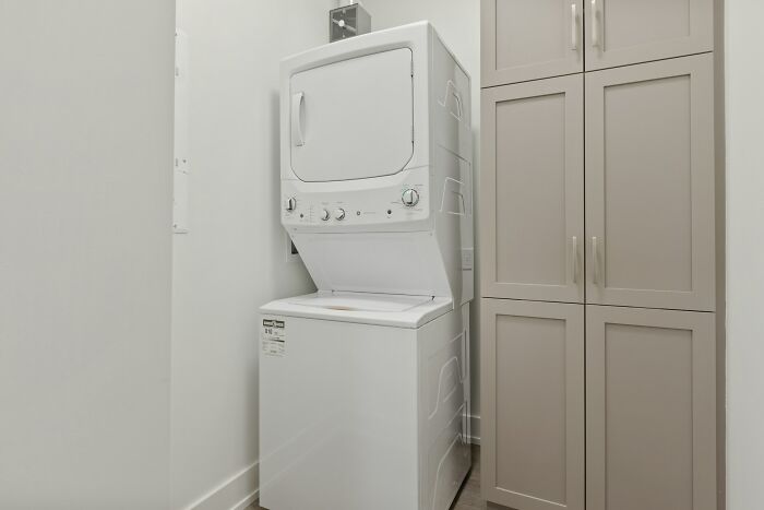 A white stacked washer and dryer unit in a small laundry room, an ordinary scene that can feel creepy.