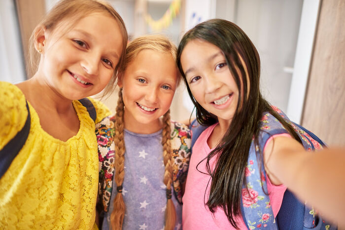 Group of primary school children smiling taking selfie
