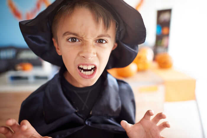 Primary child dressed as a witch showing intense psychopathic behavior expression