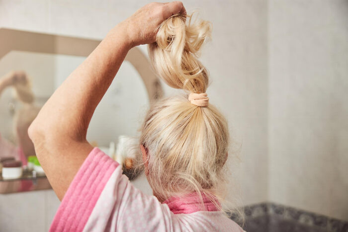 Older woman fixing hair with stress, related to psychopathic behavior
