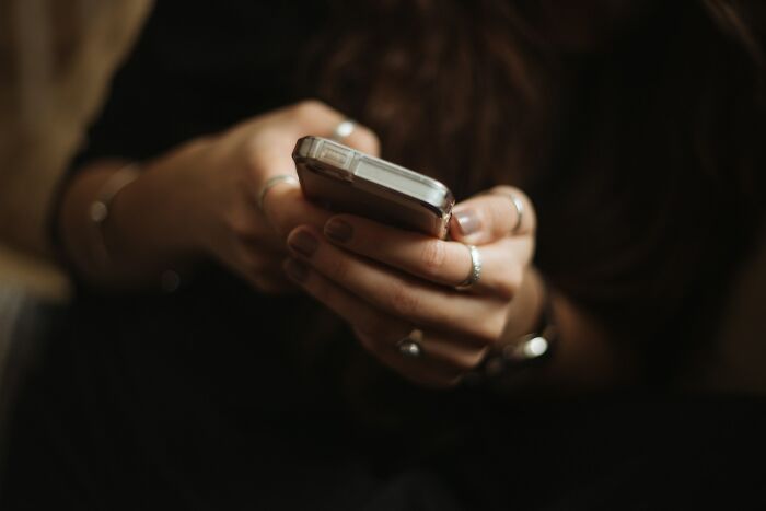 Close-up of woman texting on phone about embarrassing moments impressing men