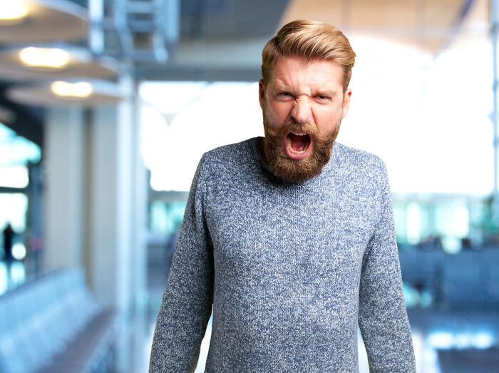 Bearded man angrily shouting indoors representing meeting a psychopath