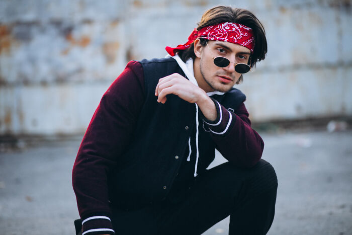 Young man with bandana and sunglasses posing with psychopath style