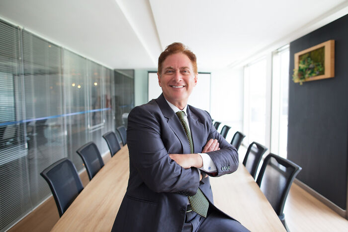 Confident businessman in suit sitting in empty meeting room